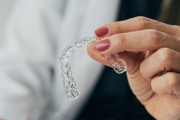 Doctor hand holding a clear dental aligner