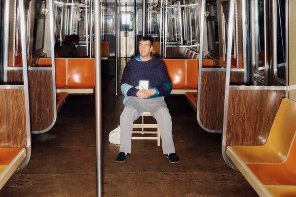 To avoid sitting on plastic, the writer brought a wooden chair to the New York City subway.
