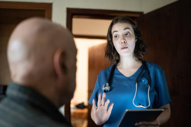 Doctor talking to a senior patient at home Doctor talking to a senior patient at home psychiatric nurse practitioner stock pictures, royalty-free photos & images