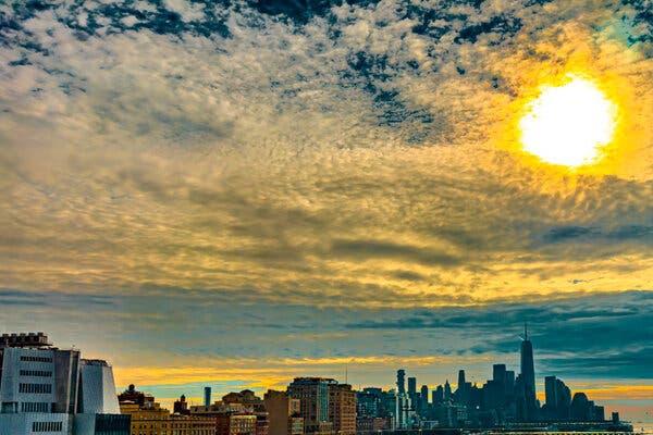 A screenshot from the Adobe Lightroom app for iPhone, showing en edited photo of Lower Manhattan under a sky of vivid blues and a bright yellow sun.