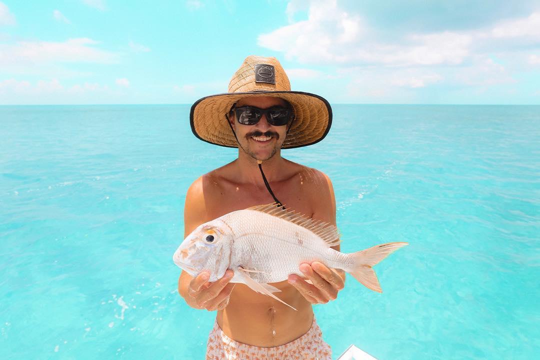 Image may contain: 1 person, hat, outdoor and water