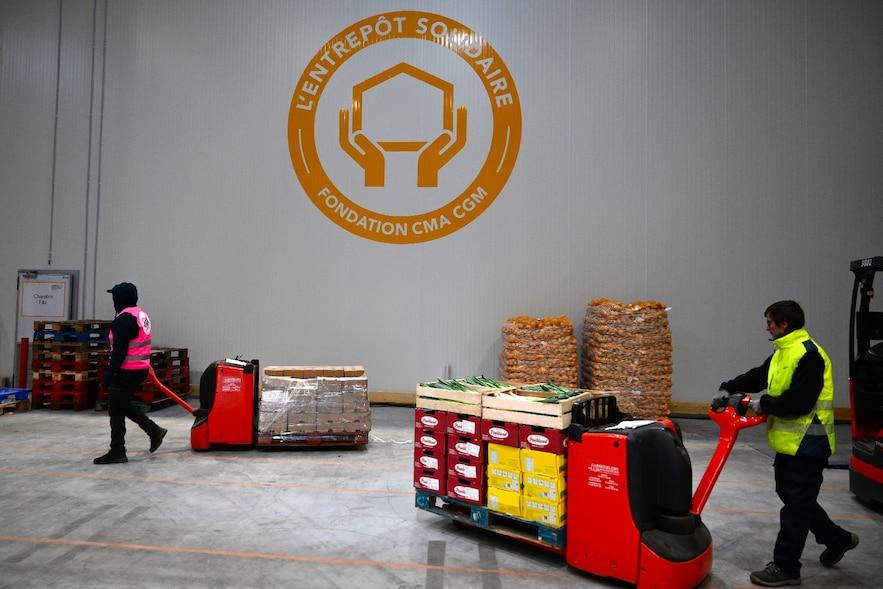 Un employé d'une ONG transporte de la nourriture dans "l'entrepôt de solidarité" à Marseille, le 5 décembre 2024