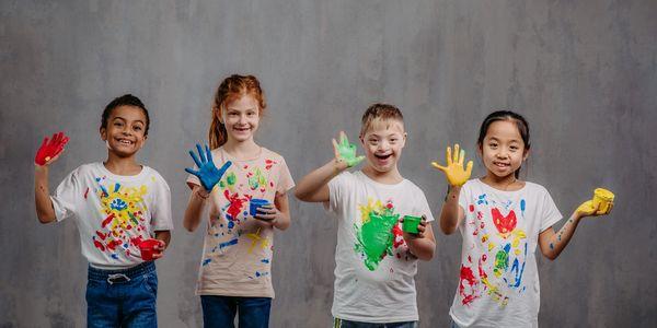 pediatric clients smiling with finger paint on their hands home care