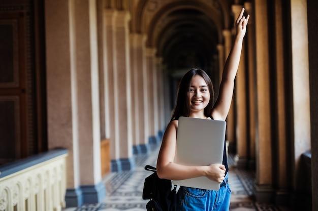 Free photo portrait of young asian woman student using a laptop or tablet in smart and happy pose at university or college,