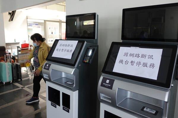 Two ferry station ticket machines that are out of order, with sheets of white paper taped on their screens.