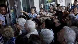 The manager of a national Bank branch delivers priority numbers to pensioners, as Greece reopened banks for pensioners who do not use cash cards for ATM, to allow them to withdraw their pension with a limit of 120 euros, in Athens on July 1, 2015. The European Union will decide whether to grant Greece a last-minute bailout package to avoid pushing it further towards an exit from the eurozone. Greece failed on the eve to make a 1.5 billion euro (1.7 billion USD) payment to the International Monetary Fund, becoming the first industrialised country to do so. AFP PHOTO / ANGELOS TZORTZINISANGELOS TZORTZINIS/AFP/Getty Images