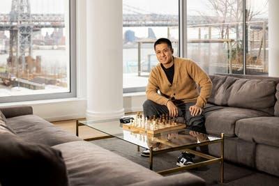 Julian Abeleda sits at a chessboard in the resident lounge of One South First. Since moving into the building last September, he has established the New York life he dreamed of back in Sacramento.