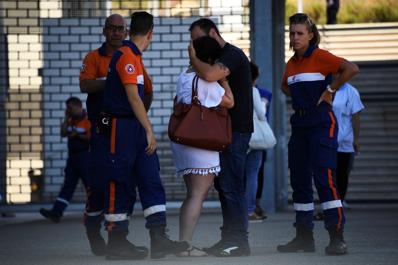 Des agents de la protection civile réconfortent une femme devant l'hôpital Pasteur de Nice, le 17 juillet 2016   / AFP