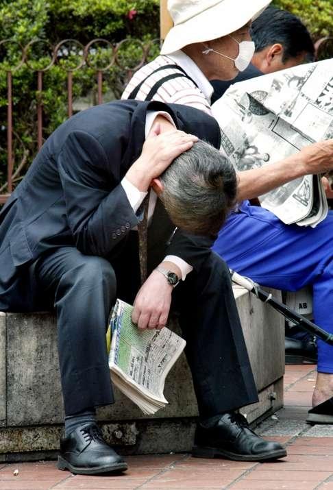 JapoÅski biznesmen siedzi na Åawce w parku w Tokio.  ZdjÄcie: AFP
