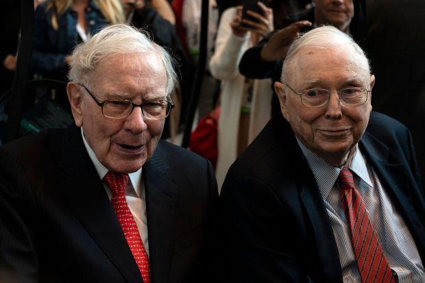 Charlie Munger (right) says his longtime business partner Warren Buffett (left) “gets a headache if...