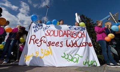 Powitanie autobusu z imigrantami w Kiel, Niemcy. Fot. Garsten Rehder/EPA