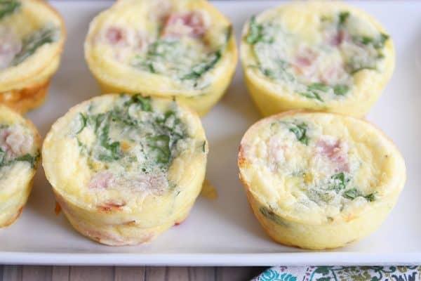 Healthy egg and veggie muffins on white tray.