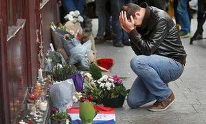 A man pays his respect outside the Le Carillon restaurant the morning after the attacks in Paris in November.