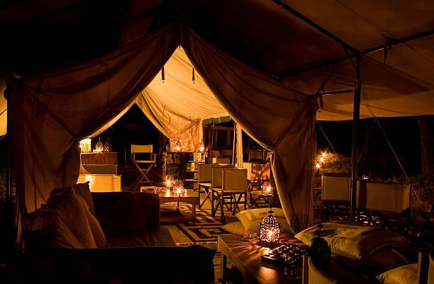 Tented safari camp by night A luxury tented safari lamp lit by torches at night Party Rentals stock pictures, royalty-free photos & images