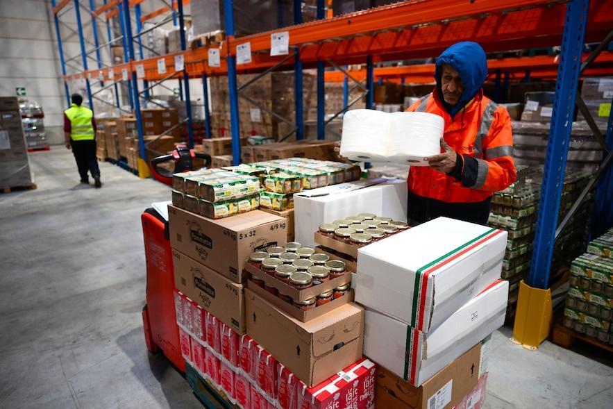 Un employé d'une ONG transporte de la nourriture dans "l'entrepôt de solidarité" à Marseille, le 5 décembre 2024