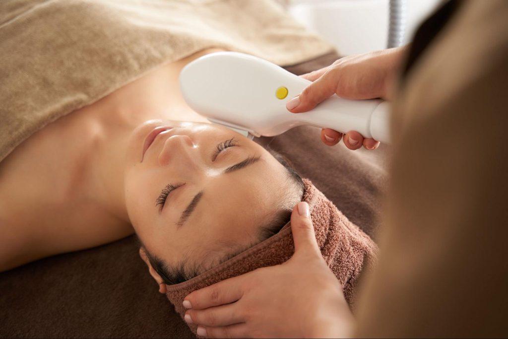 A patient comfortably receiving a Thermage radiofrequency treatment to stimulate collagen production and achieve firmer skin.