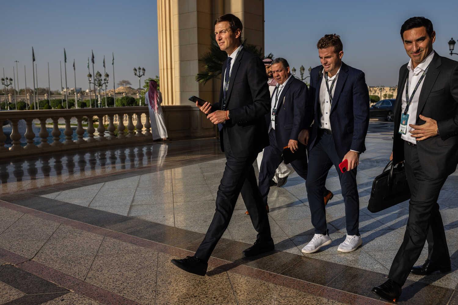 Jared Kushner wearing a suit and walking with a group of other men at a fancy hotel in Saudi Arabia.
