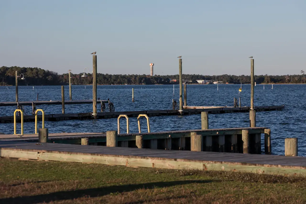 A water tower at Camp Lejeune sits on the other side of the New River across from a boat dock