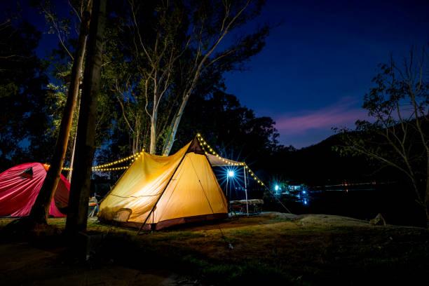 Night camping with tent at under evening sky of stars. Outdoor lifestyle and travel on summer holiday. Night camping with tent at under evening sky of stars. Outdoor lifestyle and travel on summer holiday. Party Rentals stock pictures, royalty-free photos & images