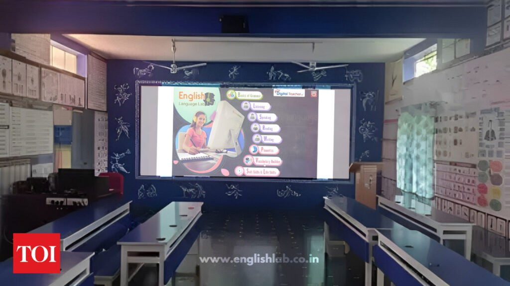 Empty Govt Language Laboratory Classroom without school students. And a banner in the background shows 'Digital Teacher English Language Lab' and displays icons for various language skills.