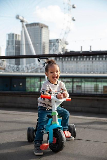 Free photo full shot happy kid on tricycle outdoors