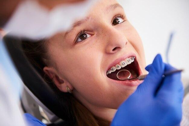 Free photo girl with braces during a routine, dental examination
