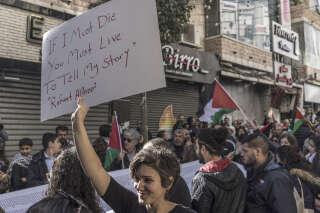 Manifestation à Ramallah, en Cisjordanie, le 11 décembre 2023. Une Palestinienne brandit une pancarte sur laquelle est inscrit un vers du poète Refaat Alareer, tué à Gaza le 7 décembre.