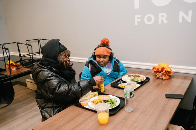 Christina et son fils Julian, bénéficiaires de la Food Bank NYC, profitent d’un repas chaud gratuit, préparé par une « cuisine communautaire » de Harlem, à New York, le 3 décembre 2025.
