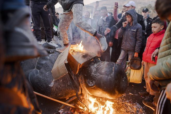 Des Syriens fêtent la chute du dictateur Bachar Al-Assad, en détruisant la statue de son père Hafez Al-Assad, place des Omeyyades, à Damas, le 15 décembre 2024.