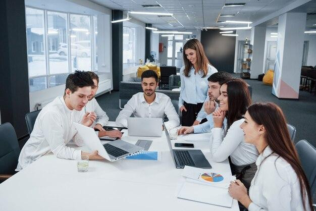 Showing good results. Group of young freelancers in the office have conversation and smiling