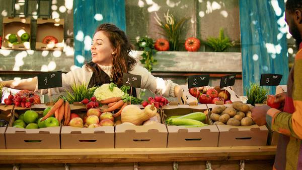 peopleenjoyingshoppinglocalfarmersmarketcheckingfreshfarmproduceyoungdiversecouplestandingfarmingstandwithvarioushomegrownorganicfruitsvegetables1.jpg
