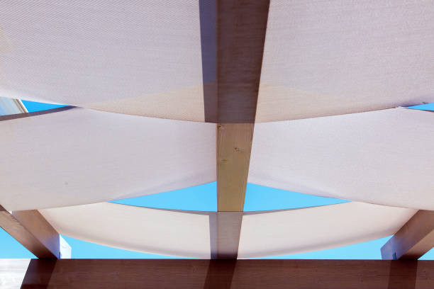 dispersed roof gazebos of textile stretched on wooden roof bars on a sunny day against a blue sky. dispersed roof gazebos of textile stretched on wooden roof bars on a sunny day against a blue sky. gazebo tensile structure stock pictures, royalty-free photos & images