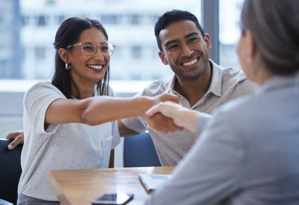 Shot of a young couple sharing a handshake with a consultant they're meeting to discuss paperwork an office You've been given love, you have to trust it new business loan stock pictures, royalty-free photos & images