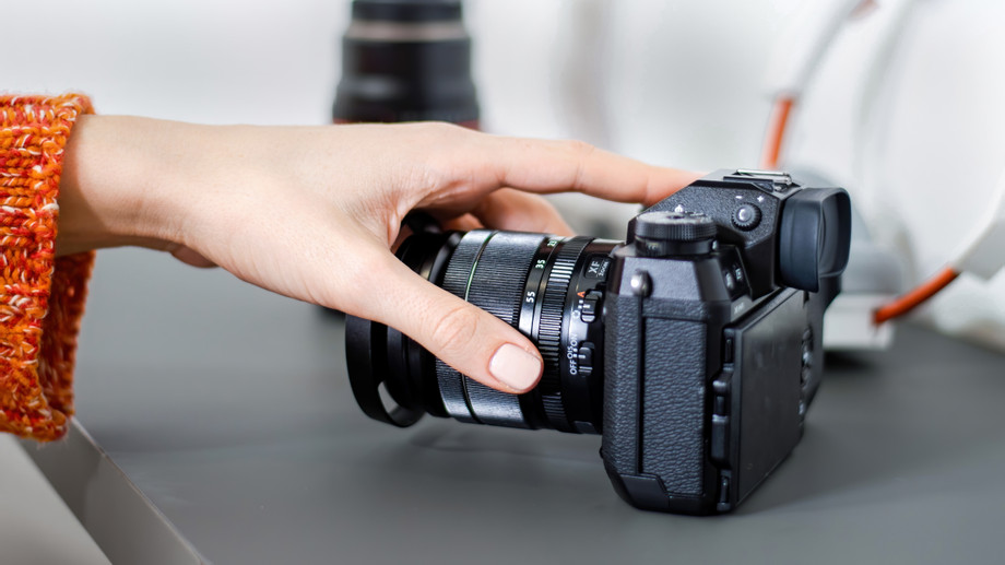 femalehandtakingcamerafromtablemicrophonecameralensheadphonesnearitworkingfromhome.jpg
