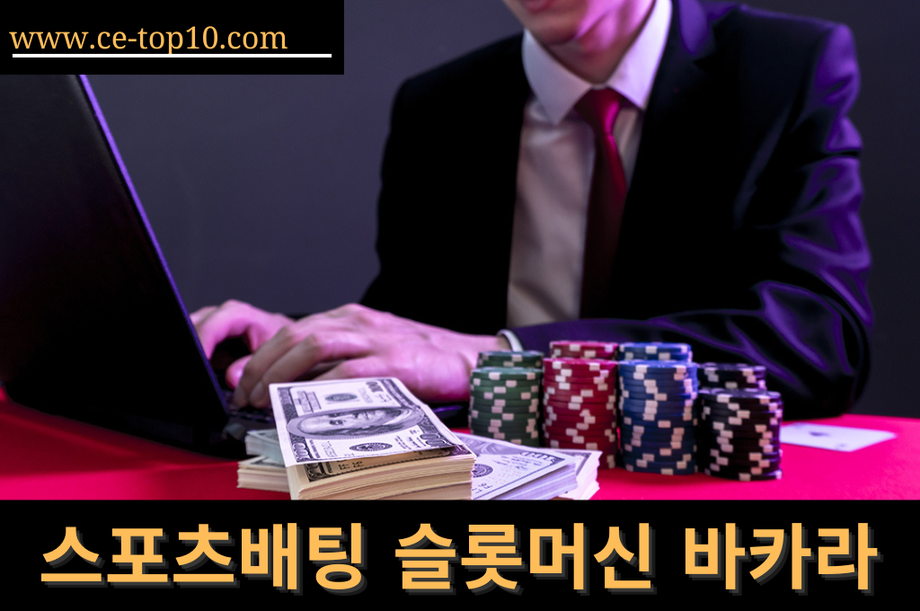 Professional man playing thru laptop in the red table with cash, cards and poker chips.