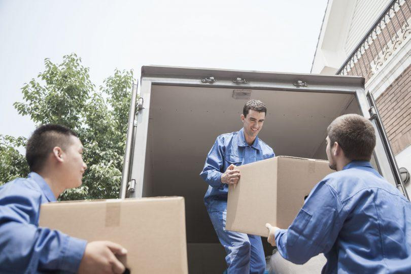 35992729_l-Movers-unloading-a-moving-van-passing-a-cardboard-box-810x540.jpg
