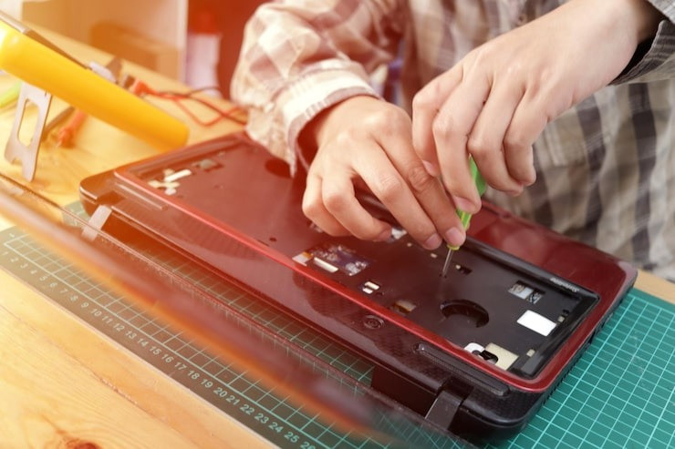 closeuptechnicianengineertryingrepairingbrokenlaptopcomputerrepairsupgrade_213362678.jpg