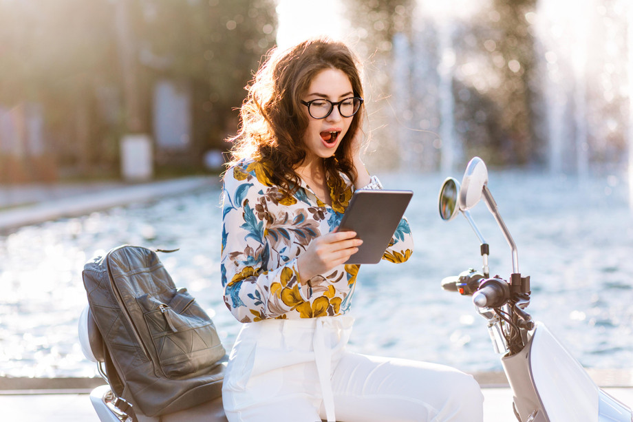 elegantfemalestudentwithleatherbackpackmapcasereadingsomethingwithsurprisedface.jpg