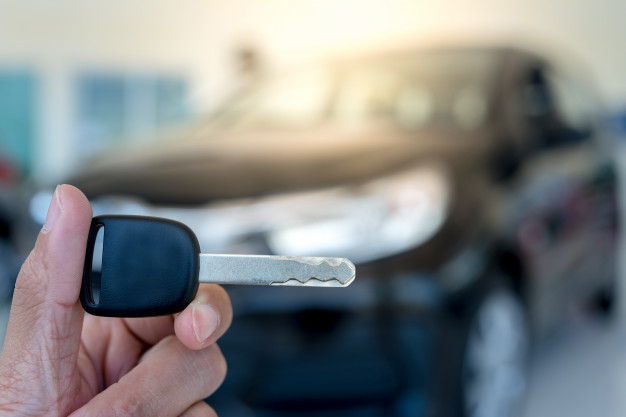 closeupcarkeyyoungmanholdingnewcarkeycarshowroomnewkey_14055566.jpg