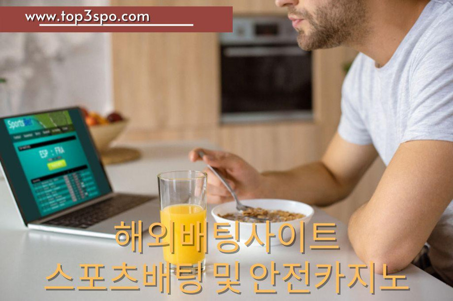 Man eating his breakfast while looking in his sport bet in laptop
