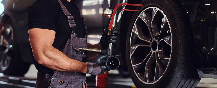 imgi_9_muscularmanisfixingcarswheelwithspecialtoolautoservice.jpeg