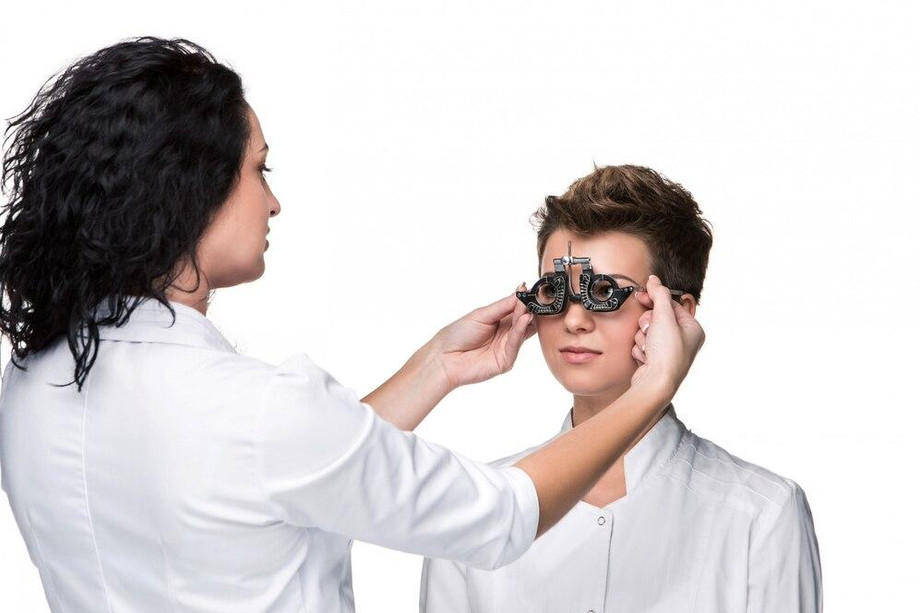 optometristholdingeyetestglassesgivingyoungwomanexamination_1550037636.jpg