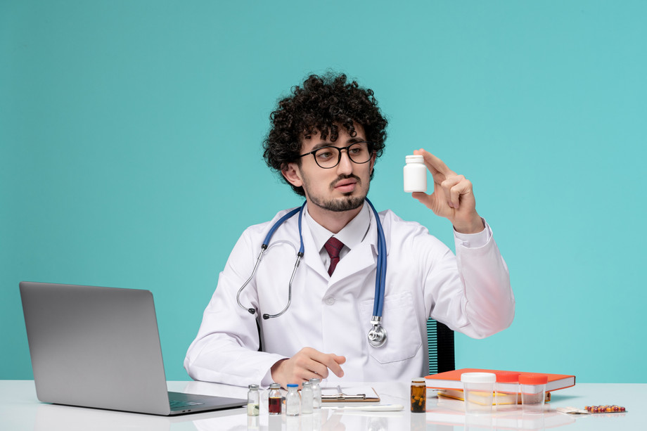 medicalyounghandsomedoctorworkingcomputerremotelylabcoatlookingmedication.jpg