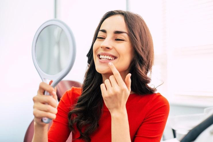 nicelookinggirlscarletsweaterisholdingmirrorhereleganthandlookingthroughperfectresultdentalwork_2836176270.jpg