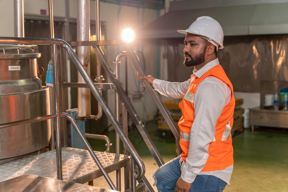 constructionworkerclimbsstairsinsidefactory.jpg