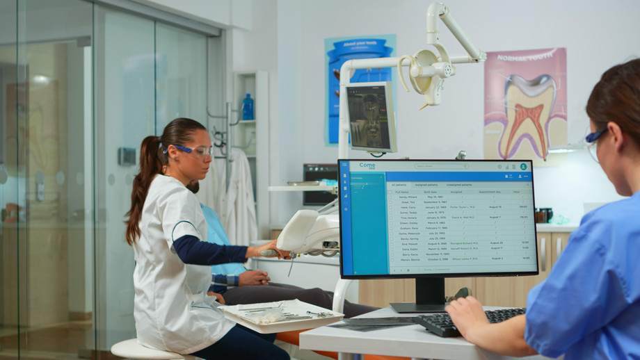 nursetypingcomputermakingappointmentswhiledentalspecialisttalkingpatientstomatologychairbeforeexaminationdentistnurseworkingtogethermodernstomatologicalclinic.jpg
