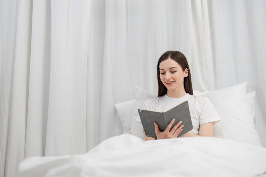 relaxedwomanrestingincozybedroomwithsoftlightingandcomfortablebeddingforapeacefulatmosphere.jpg
