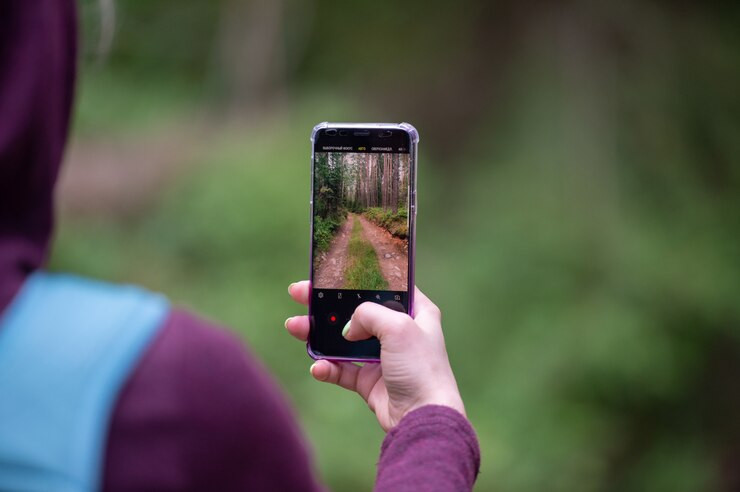 femaletakingphotoforestroadwithsmartphone_1490662105.jpg