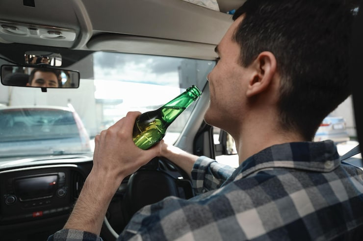 manwithbottlebeerdrivingcarcloseupdon39tdrinkdriveconcept_49542385306.jpg