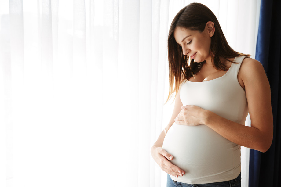 portraithappypregnantwomantouchingherbelly.jpg
